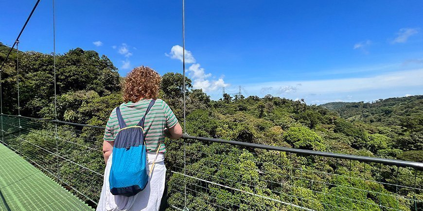 Kvinde står på en hængebro i Monteeverde i Costa Rica