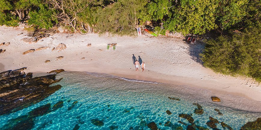 Par holder i hånden på strand på Koh Samet