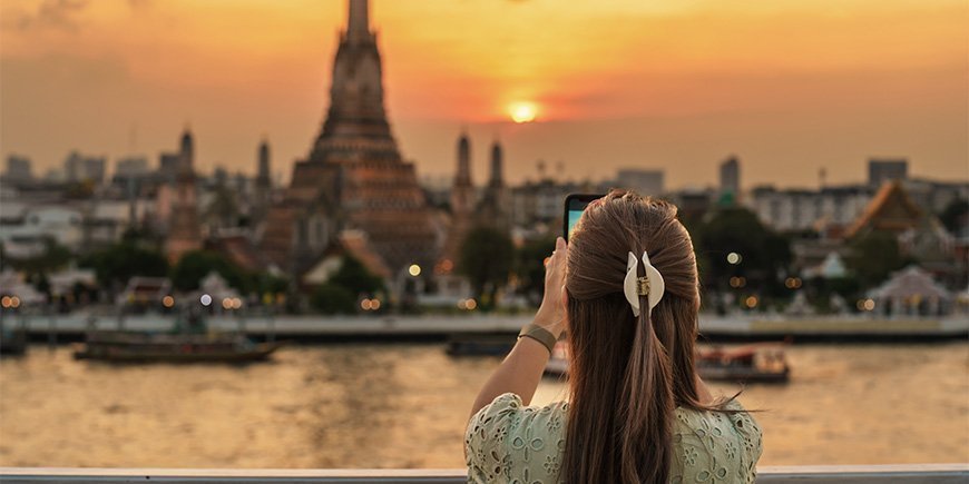 Kvinde tager billede af Wat Arun i Bangkok