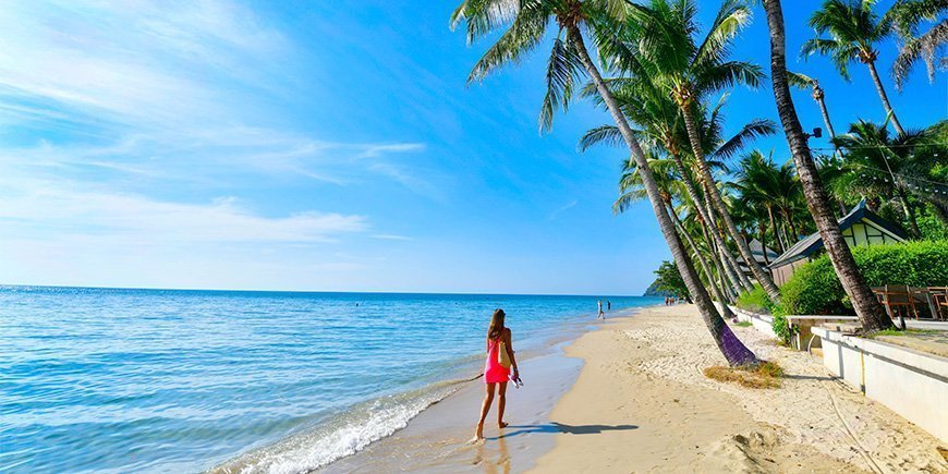 Kvinde går på stranden på Koh Chang i Thailand