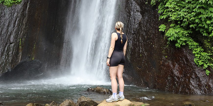 Louisa står foran Red Coral Waterfall