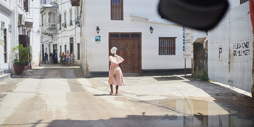 Kvinde i kjole går gennem gaderne i Stone Town